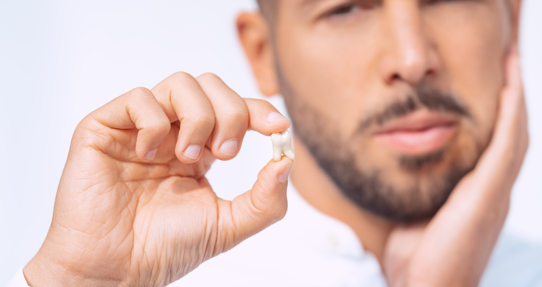 Homem com dor após extração do dente do siso